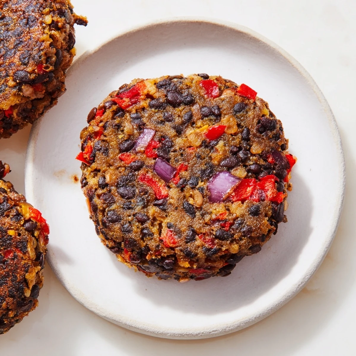 Golden brown vegetarian black bean burgers ready to be assembled with fresh toppings.