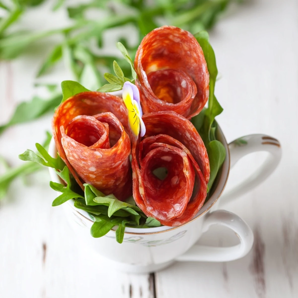Elegant The Victorian Tea Rose appetizer: salami and pepperoni roses in porcelain teacups, ready to serve.