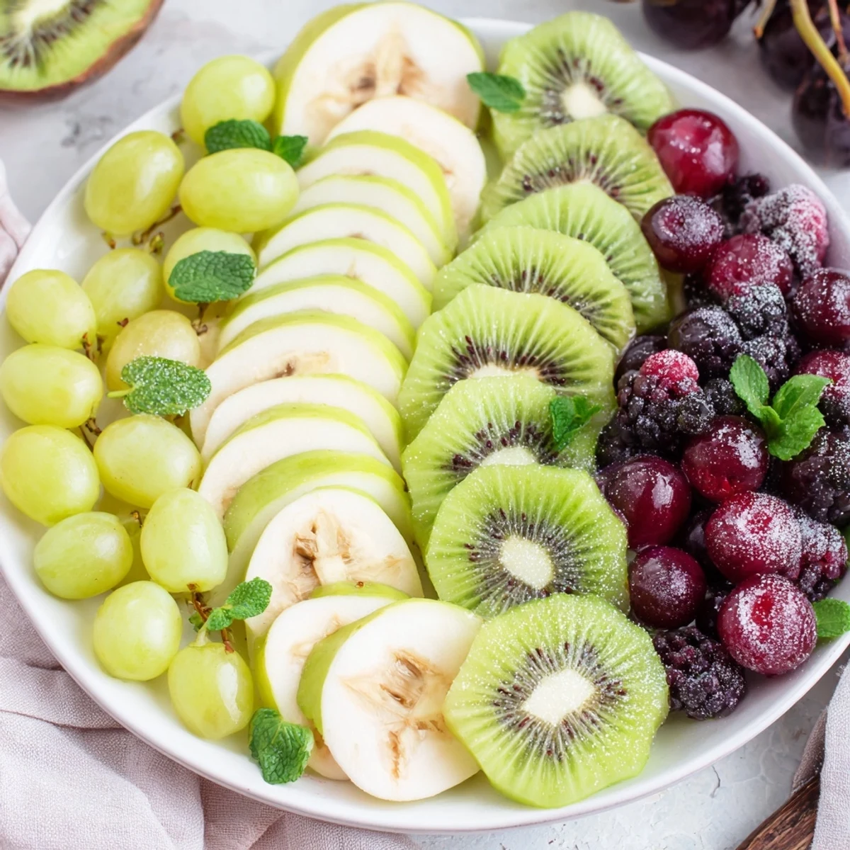 Vibrant Aurora Borealis Sweep fruit platter: green and purple fruits arranged for a stunning appetizer.