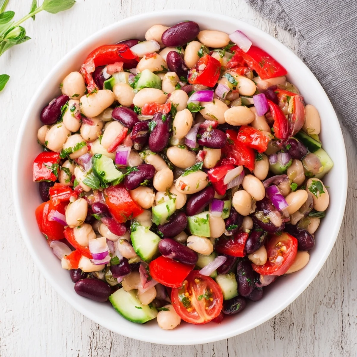 A colorful bowl of Dense Bean Salad with prosciutto, ready to eat and full of fresh flavors.