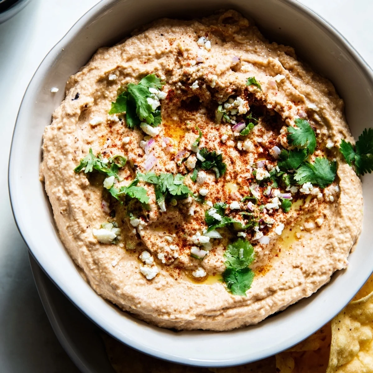 Creamy spicy black bean dip in a rustic bowl, garnished with lime wedges and fresh cilantro for a zesty Mexican-inspired appetizer.