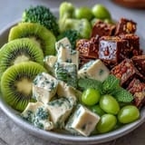 Vibrant St. Patrick's Day green food board with fresh fruits, veggies, cheeses, and snacks arranged for festive sharing.