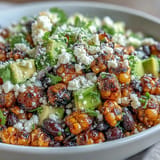 Colorful taco salad featuring charred sweet corn, hearty black beans, crisp lettuce, and a tangy cilantro-lime dressing.  