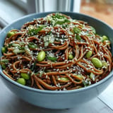 Cold sesame noodles tossed in a creamy ginger dressing, topped with fresh cucumber and cilantro, perfect for a light and healthy lunch.