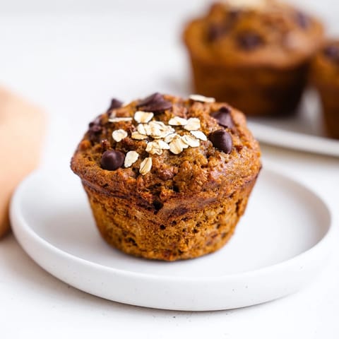 Golden-brown Freezer-Friendly Breakfast Muffins, slightly domed, sprinkled with oats, perfect for a grab-and-go breakfast.