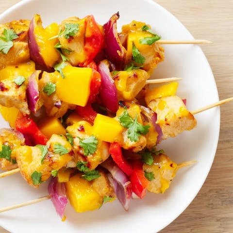 Grilled Mango Lime Chicken Skewers boasting vibrant colors from marinade and fresh cilantro garnish, close-up shot.