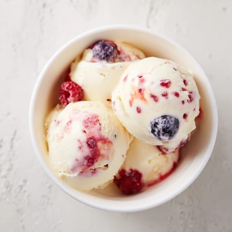 A refreshing bowl of cottage cheese ice cream, smooth and pink from blended frozen berries.