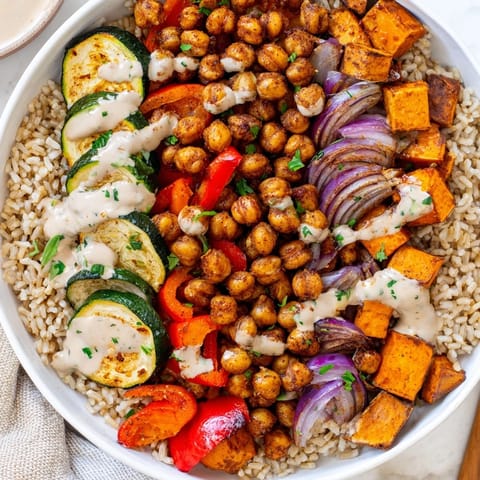 This satisfying Roasted Chickpea Buddha Bowl features fluffy rice, tahini sauce, and delicious roasted components.