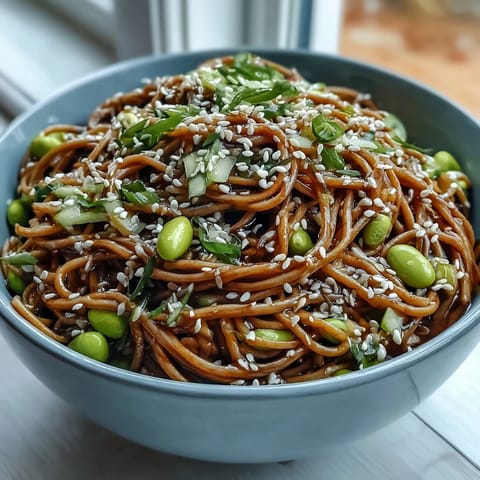Cold sesame noodles tossed in a creamy ginger dressing, topped with fresh cucumber and cilantro, perfect for a light and healthy lunch.