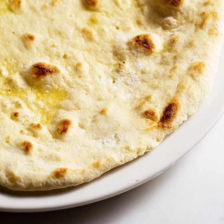 Freshly cooked Three-Ingredient Easy Flatbreads, slightly puffed with beautiful browned spots, perfect for scooping.