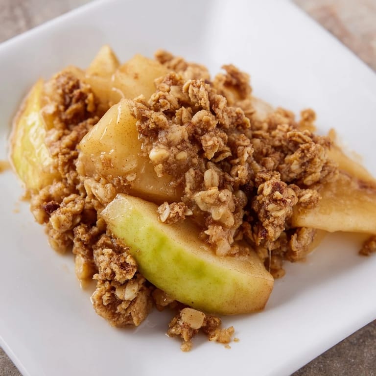 A close-up of a delicious Rustic Apple and Cinnamon Crumb Bake, perfect with a scoop of vanilla.