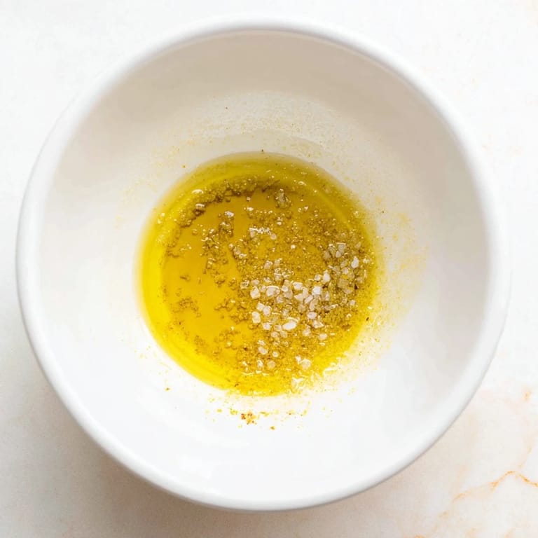 Freshly made Simple Honey Vinaigrette Salad Dressing in a clear jar, showcasing its sunny, golden color and texture.